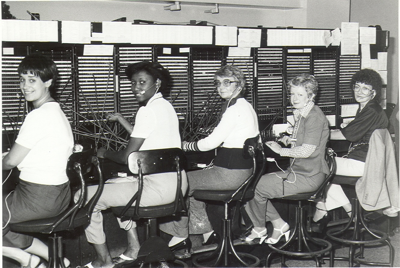 5 women look away from switchboards to take photograph